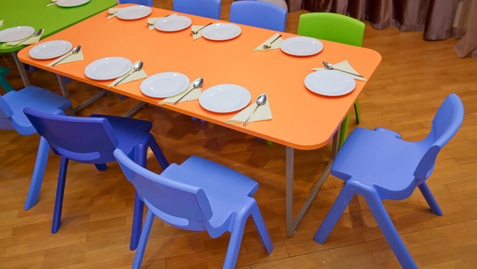 Children's table with place settings and empty chairs