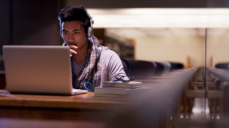High school kid with headphones browsing online about how to protect his passwords and personal info. 