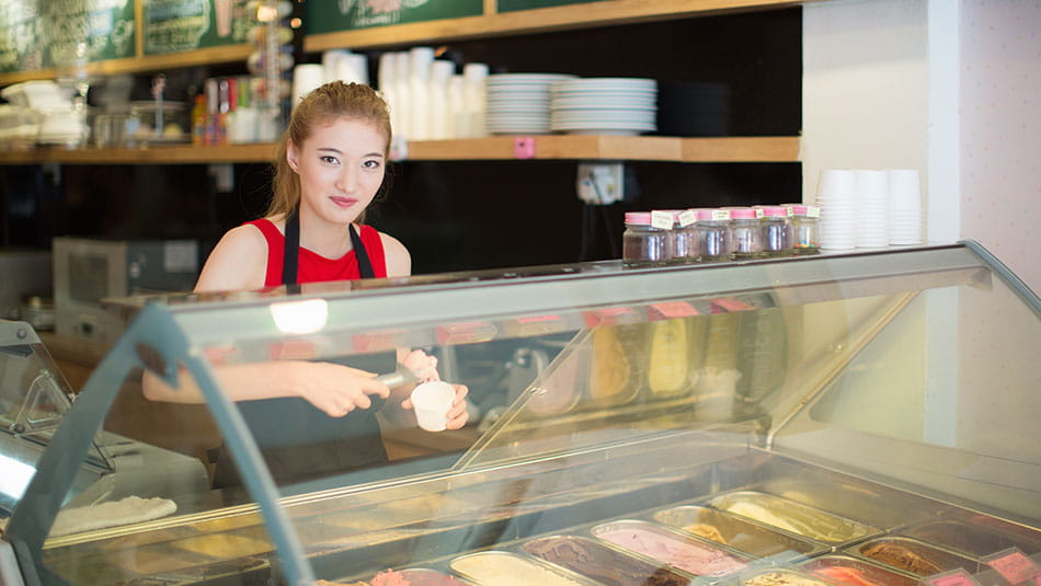 Estudiante de secundaria trabaja en una heladería y aprende el poder del ahorro y la inversión con su primer empleo.