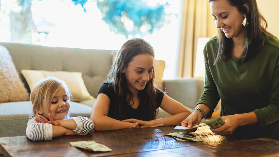 Mother teaching two daughters about finance
