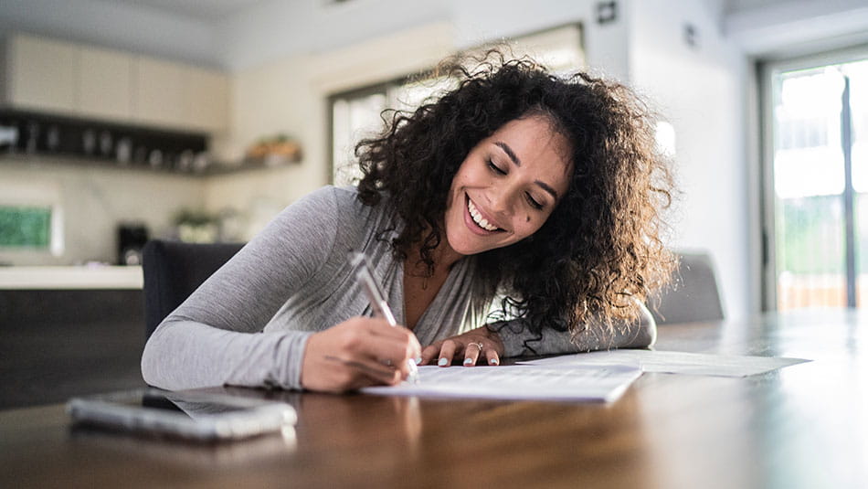 Woman signing paperwork at home