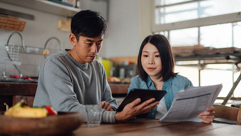 Asian couple reviewing CD rates on their iPad