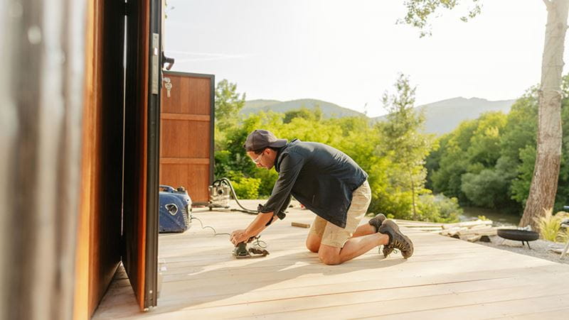 Carpintero lijando cubierta de madera