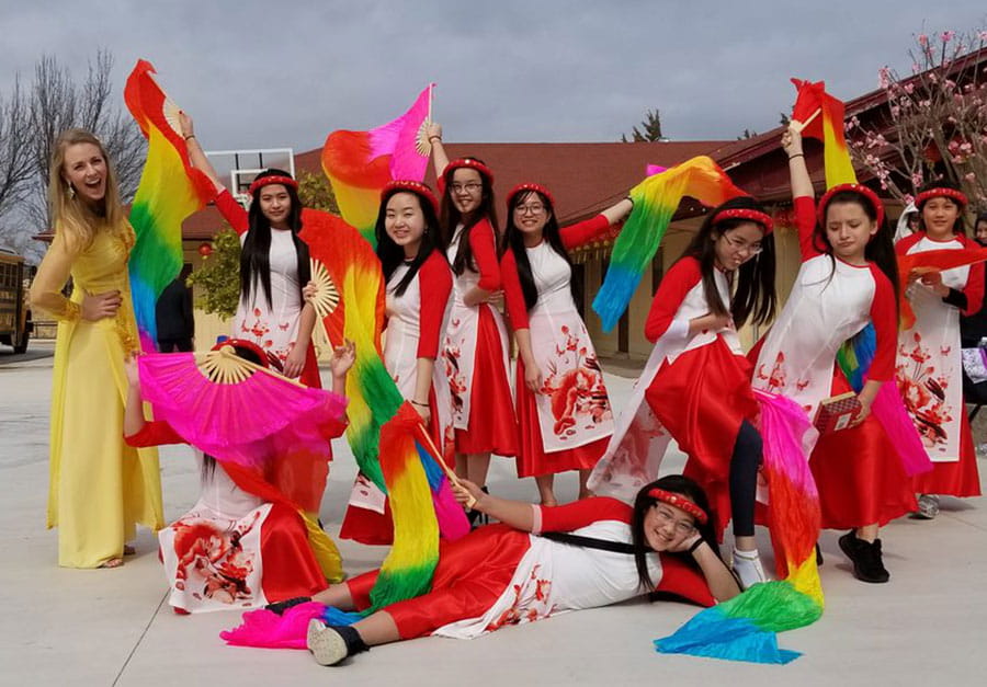 Margy Lam, who is active at her Buddhist temple, poses with youth dancers during a Lunar New Year celebration. 